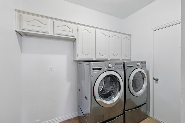 washroom with light tile patterned floors, cabinet space, independent washer and dryer, and baseboards