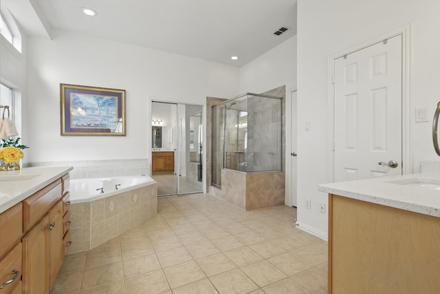 bathroom with two vanities, a bath, a stall shower, and tile patterned flooring