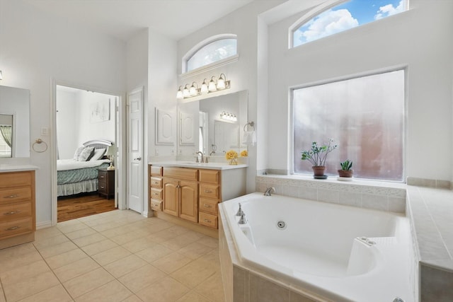 full bath featuring vanity, a high ceiling, a whirlpool tub, tile patterned flooring, and connected bathroom