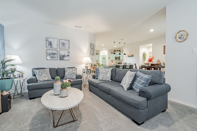 living area with recessed lighting, light colored carpet, visible vents, and baseboards