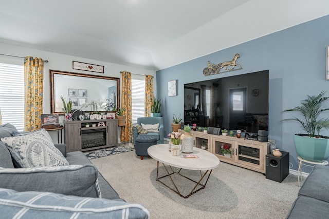 living room with vaulted ceiling, carpet flooring, a fireplace, and baseboards