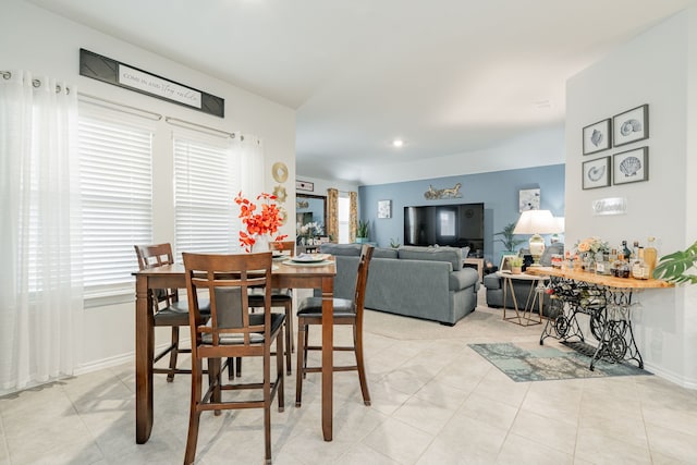 dining room with light tile patterned flooring, a healthy amount of sunlight, and baseboards