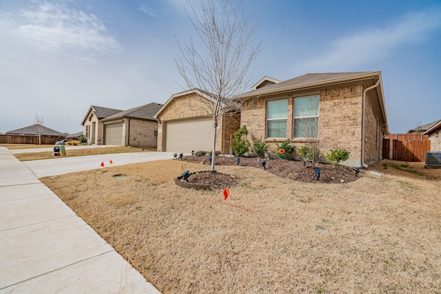 ranch-style home featuring brick siding, an attached garage, driveway, and fence