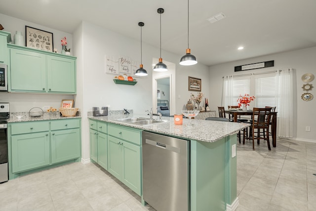 kitchen featuring a sink, stainless steel appliances, green cabinetry, and a peninsula