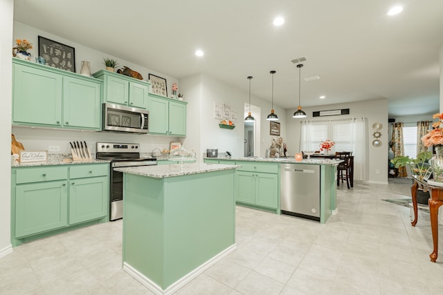 kitchen with green cabinetry, stainless steel appliances, a kitchen island, and recessed lighting