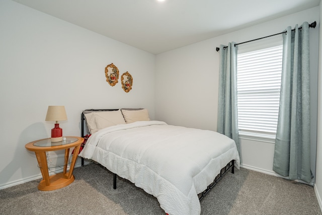 bedroom with baseboards, multiple windows, and carpet flooring