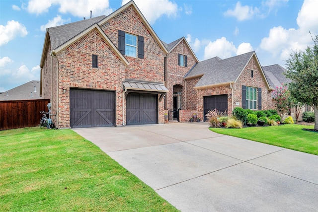 traditional-style home with driveway, brick siding, a front yard, and fence