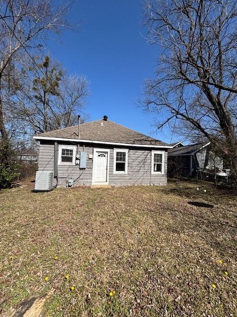 back of property with a yard and central air condition unit