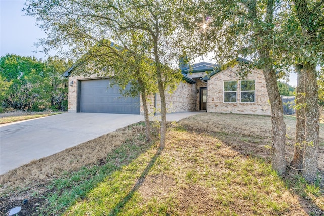 ranch-style home with a garage, brick siding, and driveway