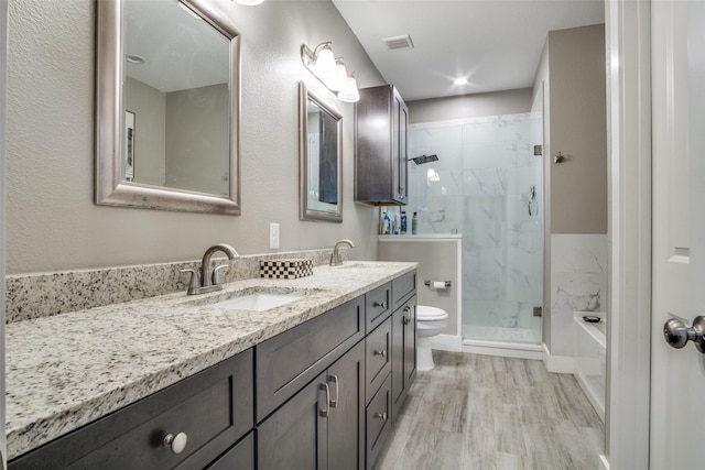 bathroom with toilet, visible vents, a marble finish shower, and a sink