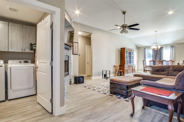 living area with washer and dryer, vaulted ceiling, visible vents, and light wood finished floors