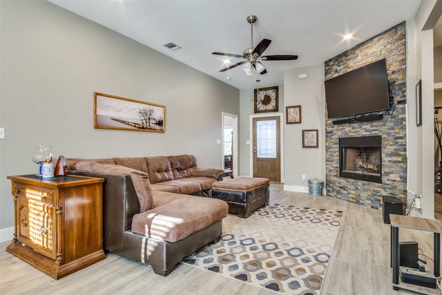 living area with a fireplace, wood finished floors, visible vents, and ceiling fan