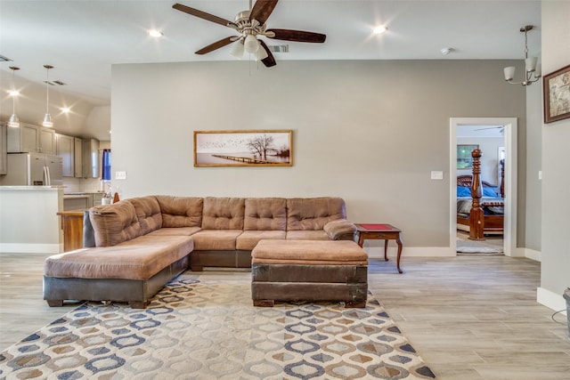 living area with lofted ceiling, baseboards, recessed lighting, light wood-style flooring, and ceiling fan with notable chandelier