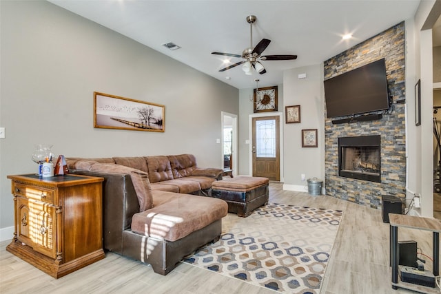 living area with visible vents, wood finished floors, a fireplace, baseboards, and ceiling fan