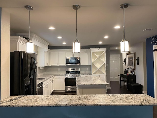 kitchen with a kitchen island, light stone countertops, recessed lighting, appliances with stainless steel finishes, and white cabinets