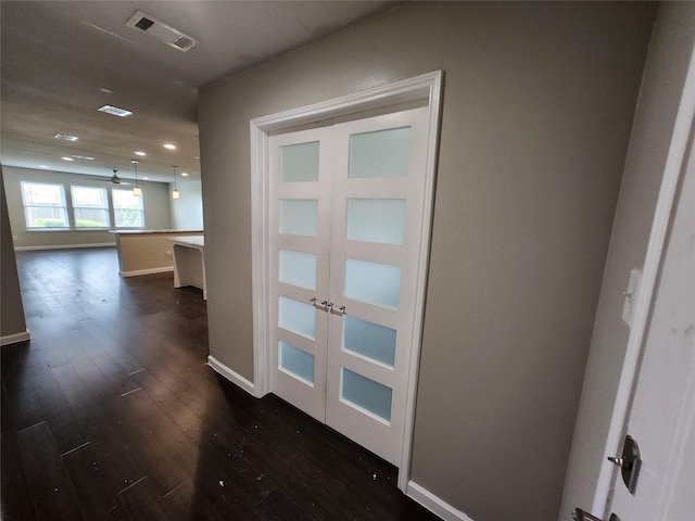 corridor with visible vents, dark wood finished floors, recessed lighting, french doors, and baseboards