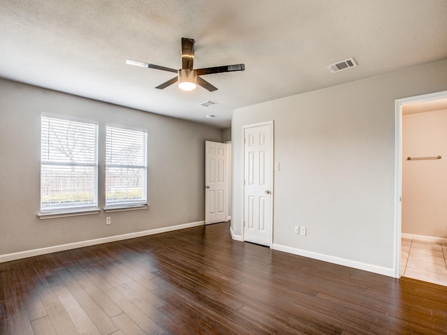 unfurnished bedroom with visible vents, baseboards, and wood finished floors