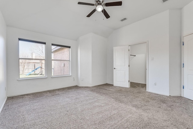 unfurnished bedroom with visible vents, a ceiling fan, carpet flooring, lofted ceiling, and a spacious closet