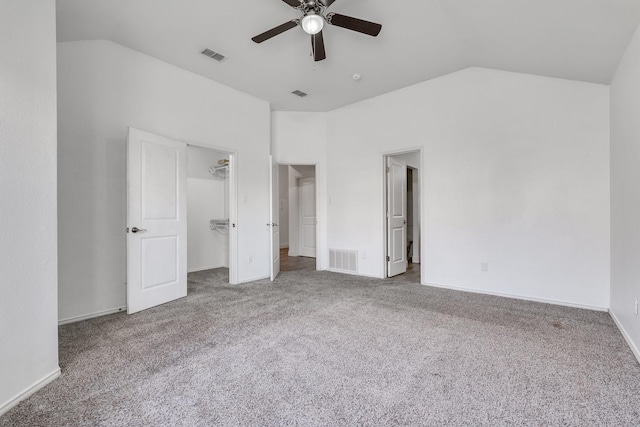 unfurnished bedroom with visible vents, lofted ceiling, and carpet floors