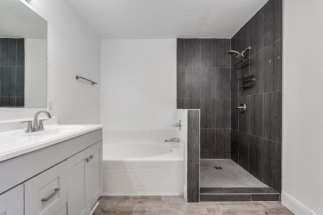 bathroom with tiled shower, vanity, a garden tub, and wood finished floors