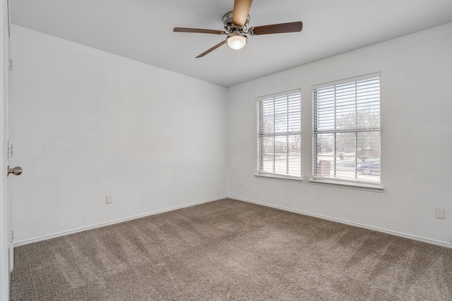 spare room featuring baseboards, ceiling fan, and carpet flooring