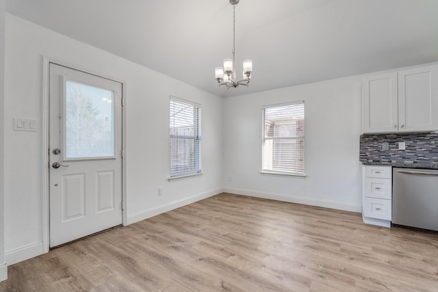 interior space featuring a notable chandelier, baseboards, and light wood-type flooring