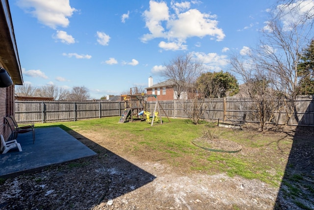 view of yard featuring a patio area, a fenced backyard, and a playground