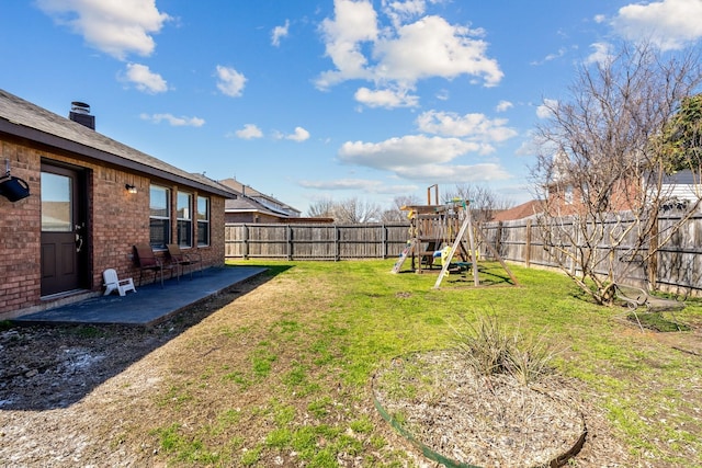 view of yard featuring a patio area, a playground, and a fenced backyard