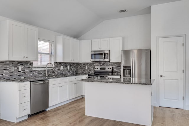 kitchen featuring dark stone countertops, stainless steel appliances, visible vents, and white cabinets