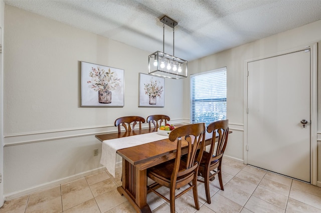 dining room with light tile patterned flooring and a textured ceiling