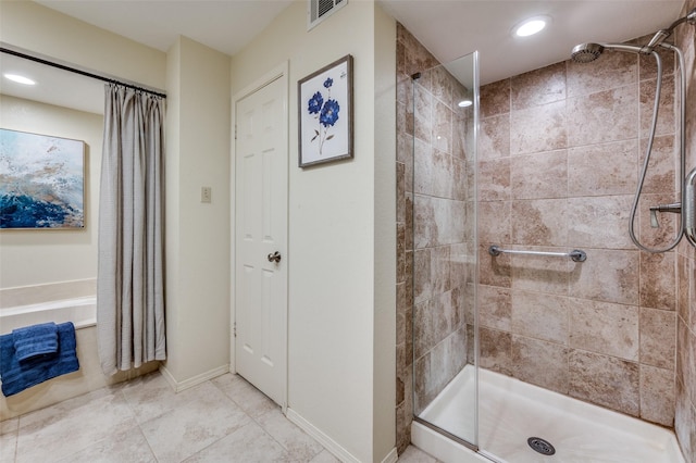 bathroom with a bathtub, visible vents, a tile shower, and baseboards