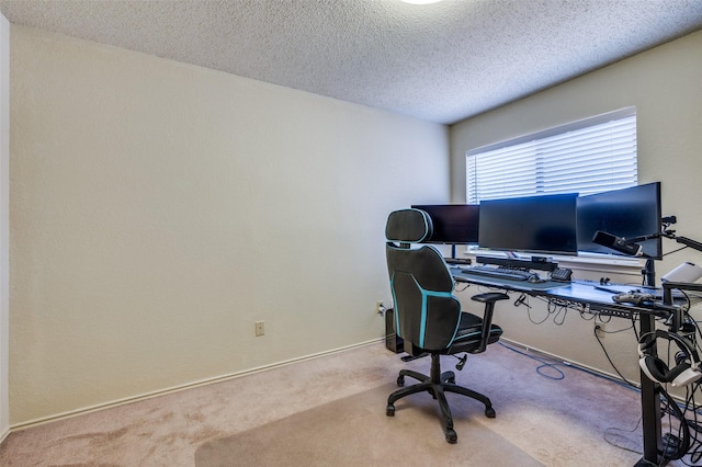 carpeted home office featuring a textured ceiling and baseboards