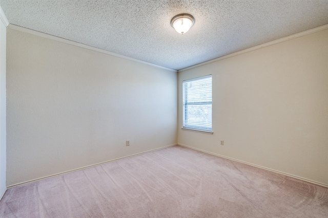 empty room with light carpet, a textured ceiling, and ornamental molding