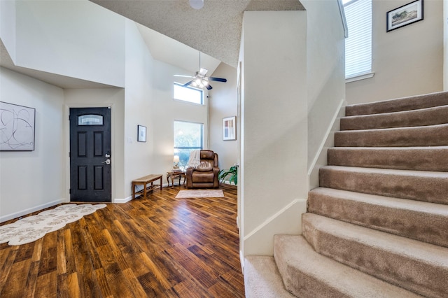 entryway featuring high vaulted ceiling, wood finished floors, stairway, baseboards, and ceiling fan