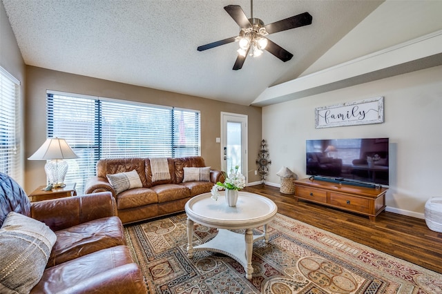 living room with plenty of natural light, wood finished floors, a ceiling fan, and vaulted ceiling