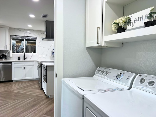 laundry area with visible vents, independent washer and dryer, a sink, recessed lighting, and laundry area