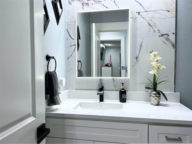 bathroom featuring vanity and a textured wall