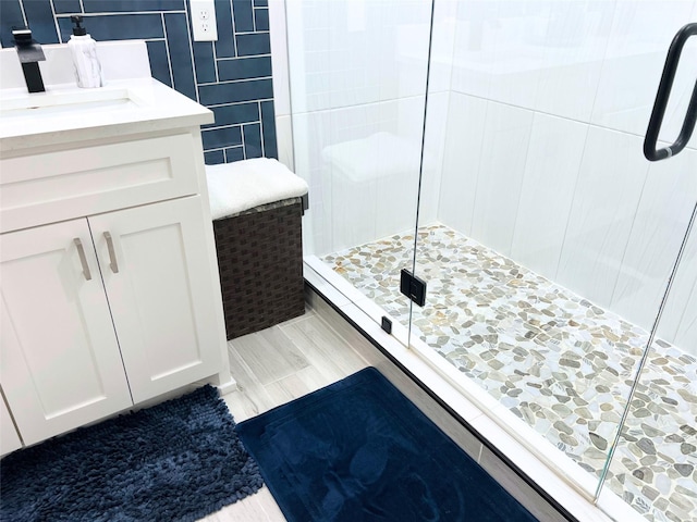 bathroom featuring tile walls, a stall shower, and vanity