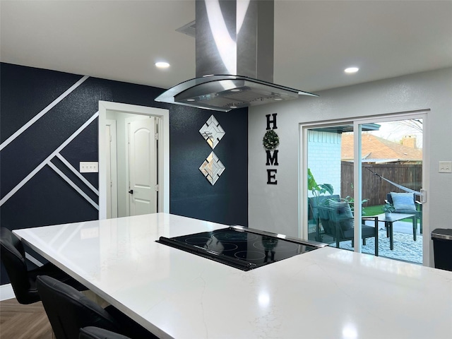 kitchen featuring cooktop, recessed lighting, island exhaust hood, and a textured wall