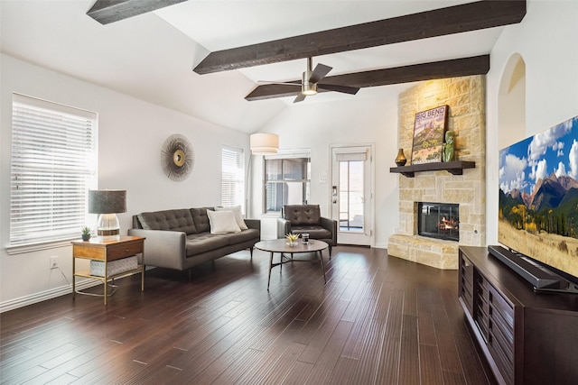 living room featuring a stone fireplace, vaulted ceiling with beams, baseboards, and dark wood-style flooring