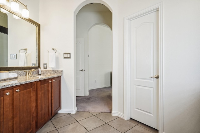 bathroom with tile patterned floors, vanity, and baseboards