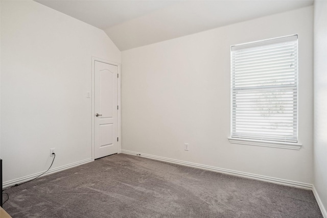 spare room featuring baseboards, carpet floors, and lofted ceiling