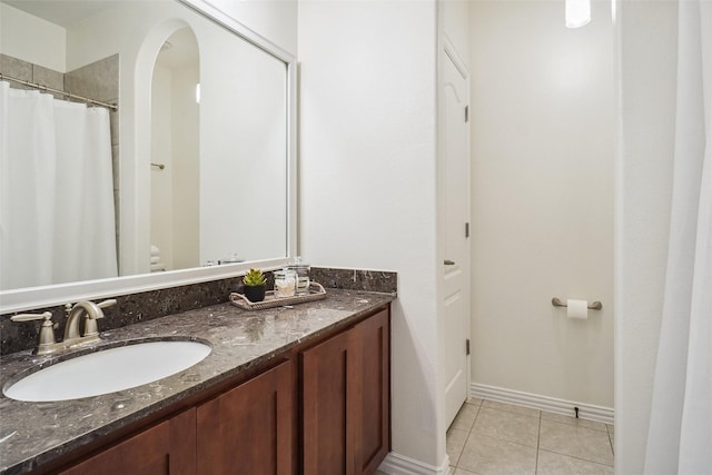 bathroom with tile patterned floors, toilet, a shower with shower curtain, baseboards, and vanity