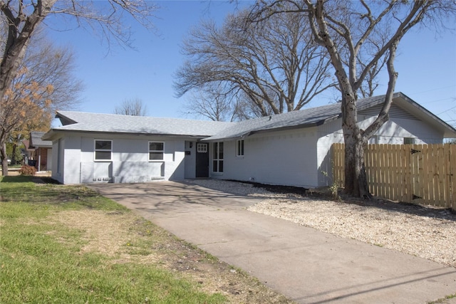 view of front of property featuring brick siding, concrete driveway, a front yard, and fence