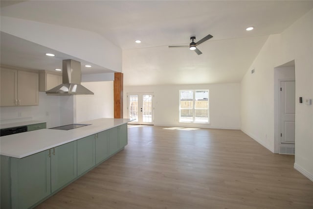 kitchen with island range hood, green cabinetry, light wood-style flooring, and vaulted ceiling