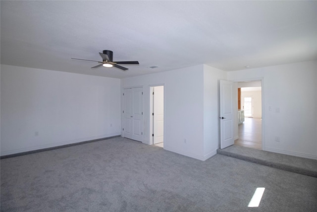 unfurnished room featuring a ceiling fan, carpet, and baseboards