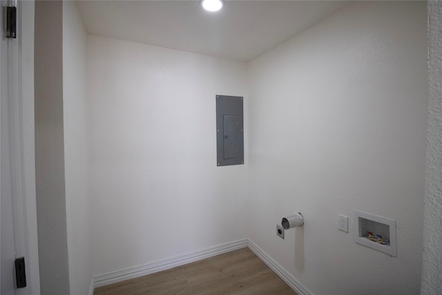 washroom featuring baseboards, laundry area, electric panel, washer hookup, and light wood-type flooring