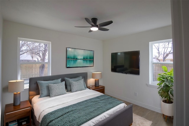 bedroom with baseboards, wood finished floors, and a ceiling fan