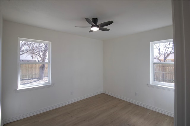 spare room featuring a ceiling fan, baseboards, and wood finished floors