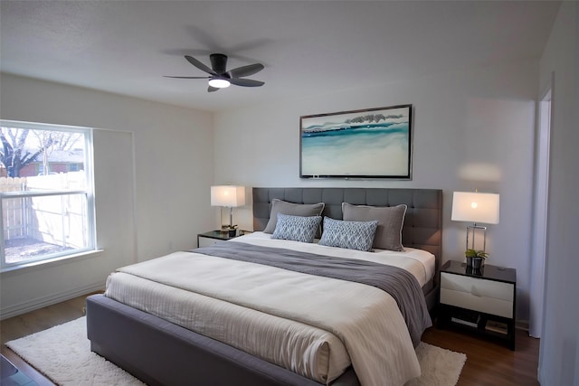 bedroom featuring wood finished floors, baseboards, and ceiling fan